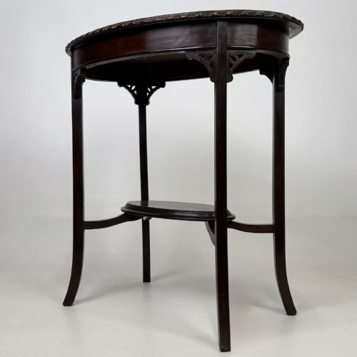 fig 5. An Edwardian oval mahogany side table featuring a carved gadrooned top edge, pierced corner brackets, slender tapered legs, and a lower oval shelf.