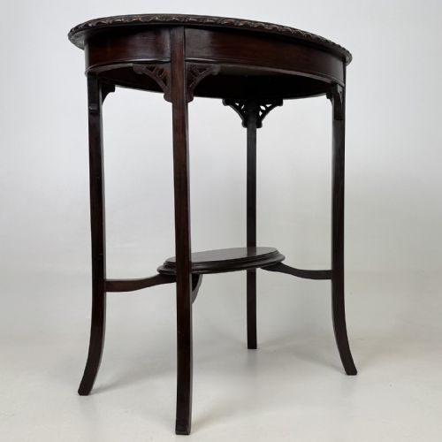 fig 7. An Edwardian oval mahogany side table featuring a carved gadrooned top edge, pierced corner brackets, slender tapered legs, and a lower oval shelf.