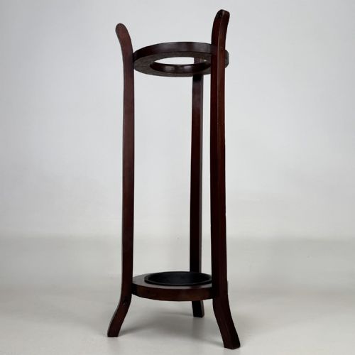 fig 1. A tall, dark mahogany three-legged umbrella stand featuring a circular top ring and a metal drip tray built into the lower ring base.