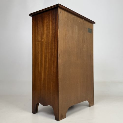 fig 3. A dark mahogany storage cabinet featuring top drawers, an extendable pull-out slide, an open alcove shelf, and a lower double door cupboard.