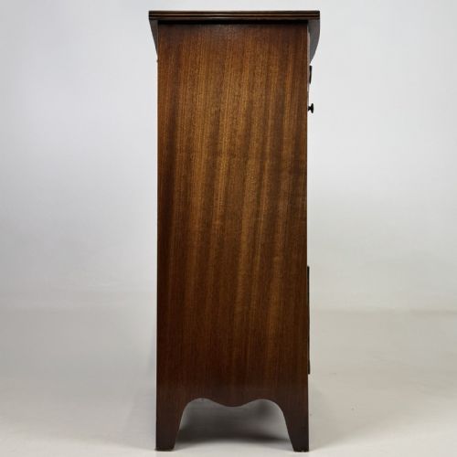 fig 6. A dark mahogany storage cabinet featuring top drawers, an extendable pull-out slide, an open alcove shelf, and a lower double door cupboard.