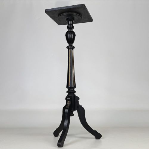 fig 3. A tall Victorian ebonised wooden plant stand featuring a square top, turned fluted column with gilt highlights, and a curved tripod base.