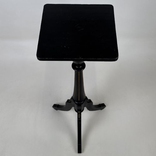 fig 5. A tall Victorian ebonised wooden plant stand featuring a square top, turned fluted column with gilt highlights, and a curved tripod base.