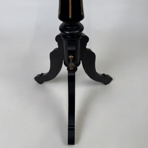 fig 7. A tall Victorian ebonised wooden plant stand featuring a square top, turned fluted column with gilt highlights, and a curved tripod base.