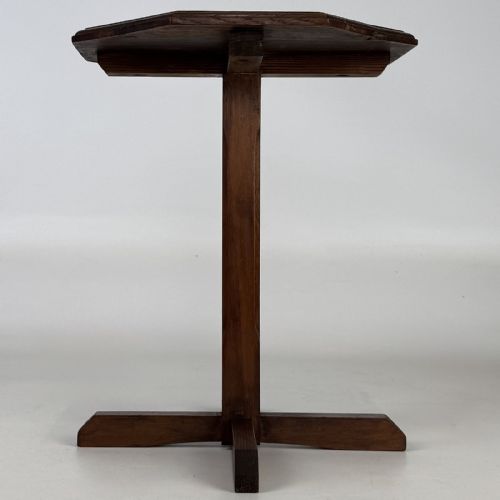 fig 1. An antique dark oak side table featuring an octagonal top, a central chamfered pedestal, and a four-point cruciform base.