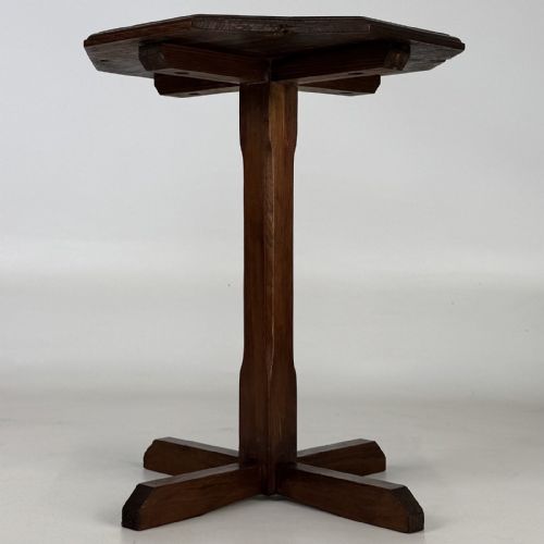 fig 3. An antique dark oak side table featuring an octagonal top, a central chamfered pedestal, and a four-point cruciform base.