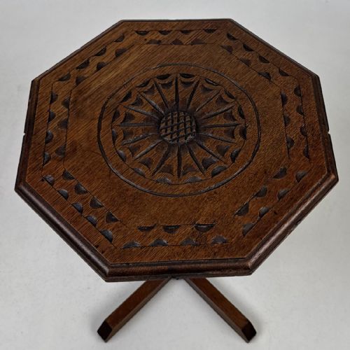fig 5. An antique dark oak side table featuring an octagonal top, a central chamfered pedestal, and a four-point cruciform base.