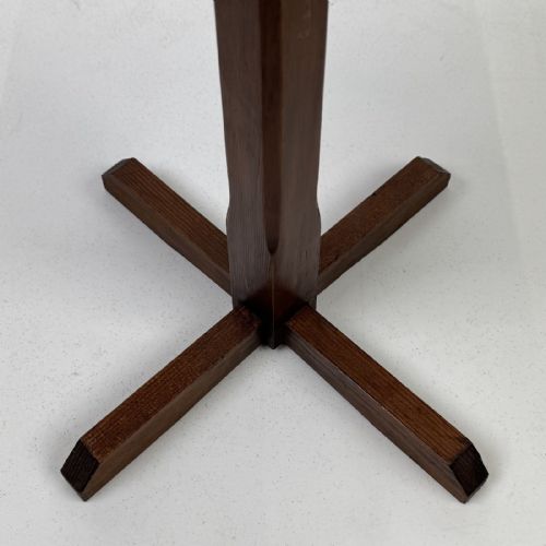 fig 6. An antique dark oak side table featuring an octagonal top, a central chamfered pedestal, and a four-point cruciform base.