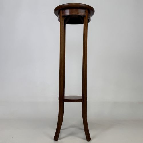 fig 2. A tall Edwardian mahogany plant stand featuring a circular top, long slender legs, and a small circular lower shelf.