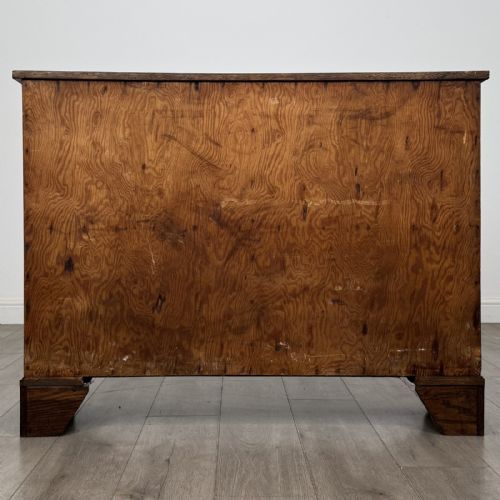 fig 6. A low Victorian dark oak display cabinet featuring two glazed doors, turned wooden knobs, bracket feet, and a single interior shelf trimmed with scalloped leather.