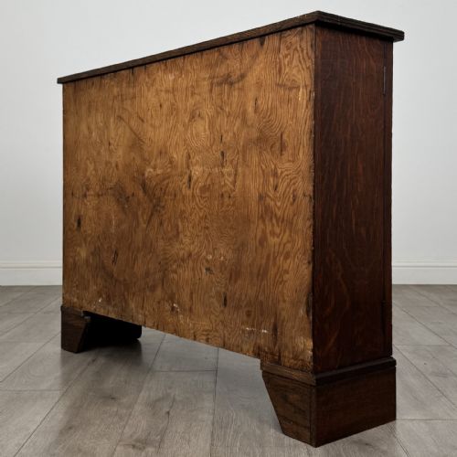fig 7. A low Victorian dark oak display cabinet featuring two glazed doors, turned wooden knobs, bracket feet, and a single interior shelf trimmed with scalloped leather.