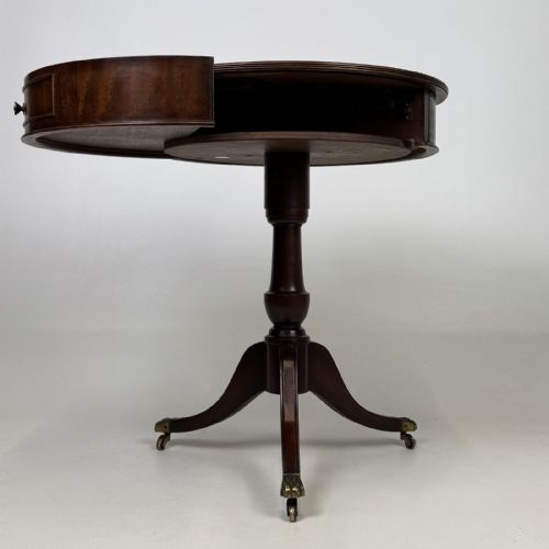 fig 1. An Edwardian mahogany drum table featuring a circular top with a frieze drawer, supported by a turned pedestal and tripod swept legs on brass claw castors.