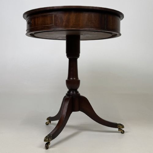 fig 2. An Edwardian mahogany drum table featuring a circular top with a frieze drawer, supported by a turned pedestal and tripod swept legs on brass claw castors.