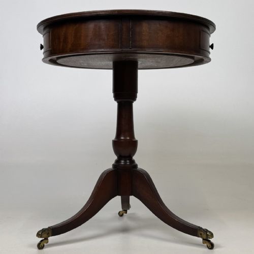 fig 3. An Edwardian mahogany drum table featuring a circular top with a frieze drawer, supported by a turned pedestal and tripod swept legs on brass claw castors.
