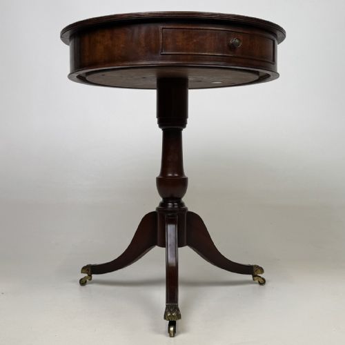 fig 4. An Edwardian mahogany drum table featuring a circular top with a frieze drawer, supported by a turned pedestal and tripod swept legs on brass claw castors.