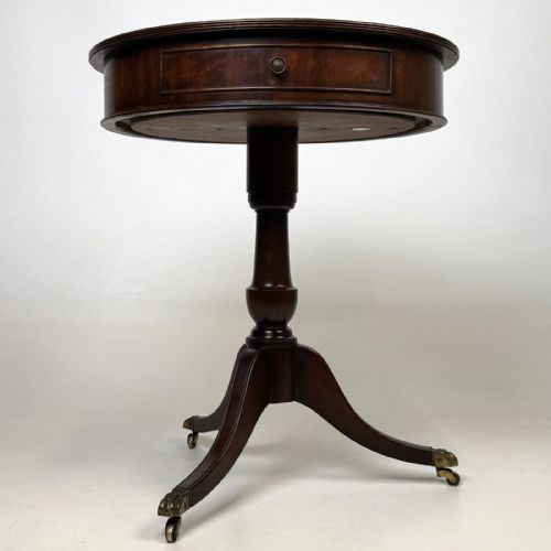 fig 6. An Edwardian mahogany drum table featuring a circular top with a frieze drawer, supported by a turned pedestal and tripod swept legs on brass claw castors.