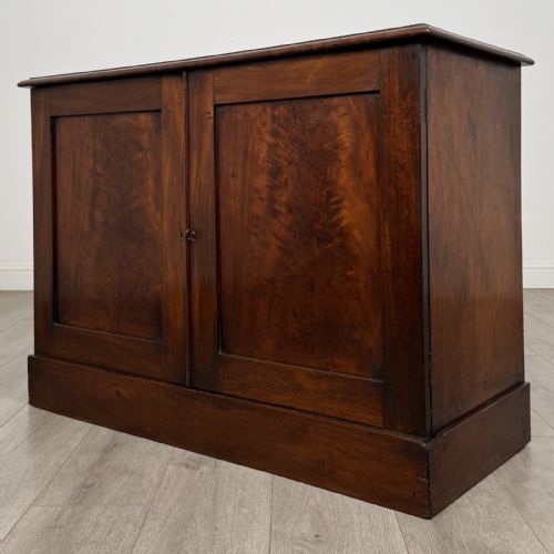 fig 2. A Victorian mahogany collectors cabinet featuring flame mahogany twin panel doors and a wide plinth base.
