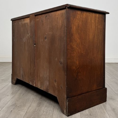 fig 6. A Victorian mahogany collectors cabinet featuring flame mahogany twin panel doors and a wide plinth base.