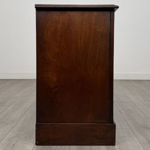 fig 7. A Victorian mahogany collectors cabinet featuring flame mahogany twin panel doors and a wide plinth base.