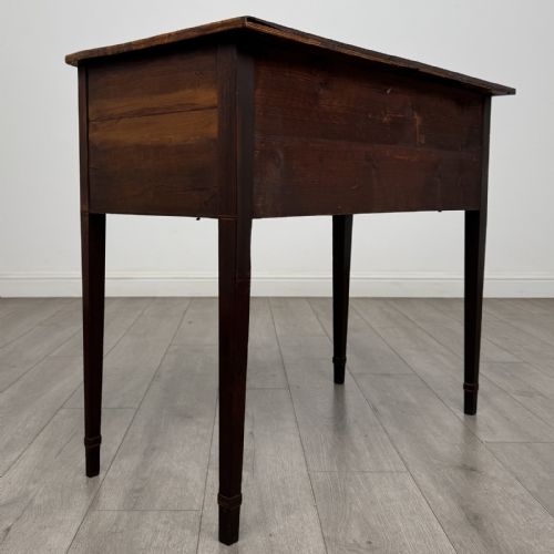fig 3. An antique Georgian mahogany bow-front side table with flame mahogany inlaid drawers, brass ring handles, and tapered square legs.