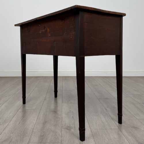fig 5. An antique Georgian mahogany bow-front side table with flame mahogany inlaid drawers, brass ring handles, and tapered square legs.