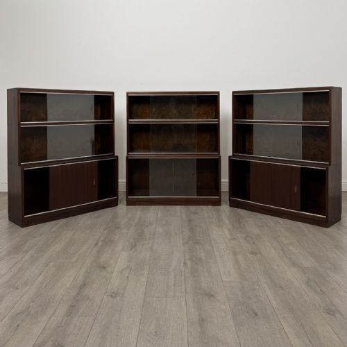 fig 1. A set of three dark mahogany modular cabinets featuring sliding glass doors and lower wood storage compartments.