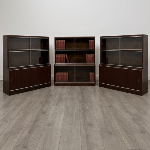 fig 2. A set of three dark mahogany modular cabinets featuring sliding glass doors and lower wood storage compartments.