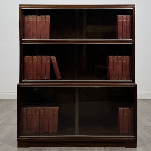 fig 3. A set of three dark mahogany modular cabinets featuring sliding glass doors and lower wood storage compartments.