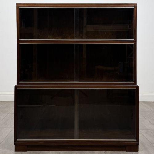 fig 4. A set of three dark mahogany modular cabinets featuring sliding glass doors and lower wood storage compartments.