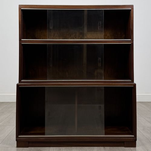 fig 2. A dark mahogany three-tier display cabinet featuring sliding glass doors and a rectangular plinth base.