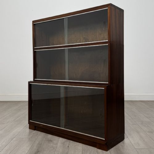 fig 3. A dark mahogany three-tier display cabinet featuring sliding glass doors and a rectangular plinth base.