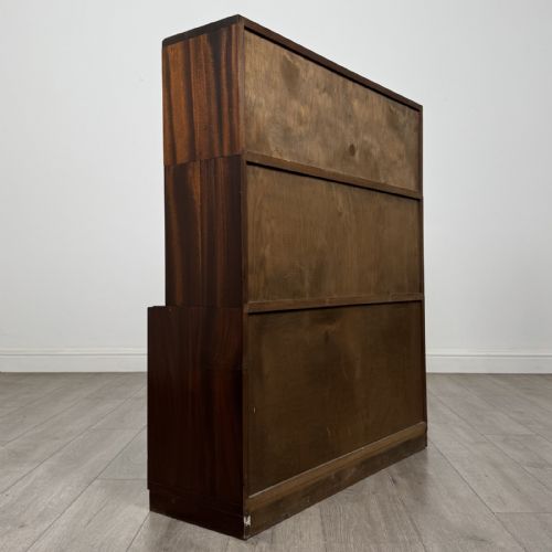 fig 5. A dark mahogany three-tier display cabinet featuring sliding glass doors and a rectangular plinth base.