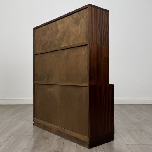 fig 7. A dark mahogany three-tier display cabinet featuring sliding glass doors and a rectangular plinth base.