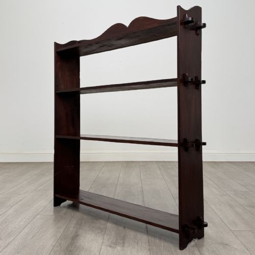 fig 2. A dark mahogany open bookcase featuring four tiered open shelves and a shaped, scalloped raised gallery back.
