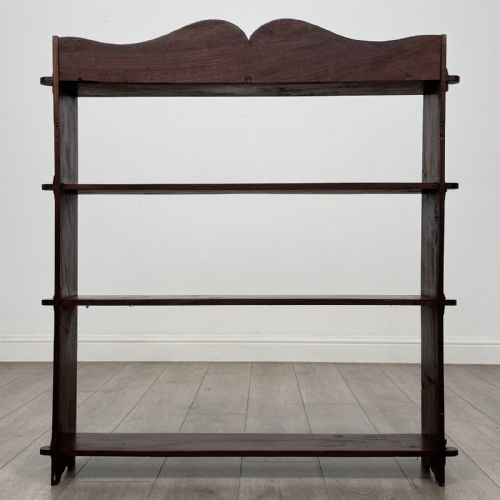 fig 5. A dark mahogany open bookcase featuring four tiered open shelves and a shaped, scalloped raised gallery back.