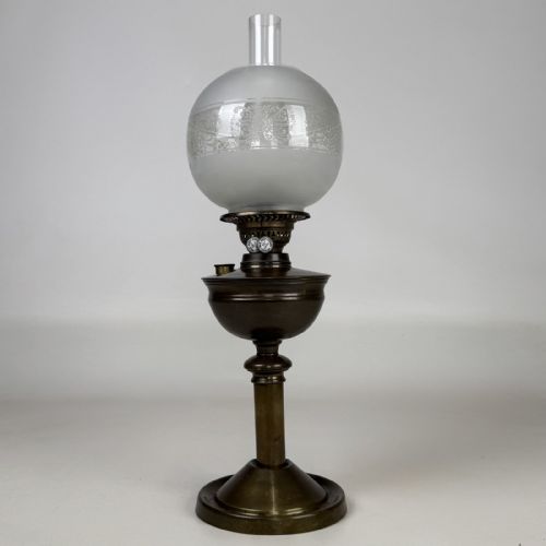 fig 1. An antique Victorian brass oil lamp featuring a circular stepped base, a columnar pedestal supporting a round brass reservoir, a burner assembly, a spherical etched frosted glass shade, and a clear glass chimney.