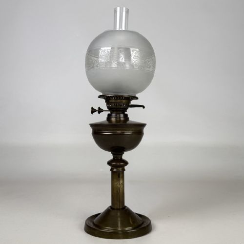 fig 2. An antique Victorian brass oil lamp featuring a circular stepped base, a columnar pedestal supporting a round brass reservoir, a burner assembly, a spherical etched frosted glass shade, and a clear glass chimney.