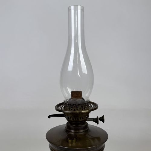 fig 4. An antique Victorian brass oil lamp featuring a circular stepped base, a columnar pedestal supporting a round brass reservoir, a burner assembly, a spherical etched frosted glass shade, and a clear glass chimney.
