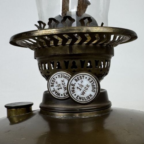 fig 6. An antique Victorian brass oil lamp featuring a circular stepped base, a columnar pedestal supporting a round brass reservoir, a burner assembly, a spherical etched frosted glass shade, and a clear glass chimney.