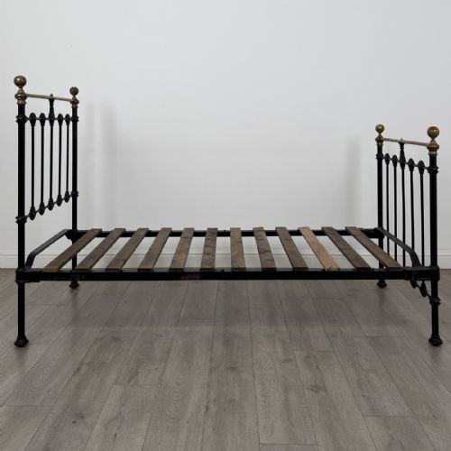 fig 2. A Victorian single bed frame constructed from black cast iron spindles and topped with a brass top rail and ball finials.