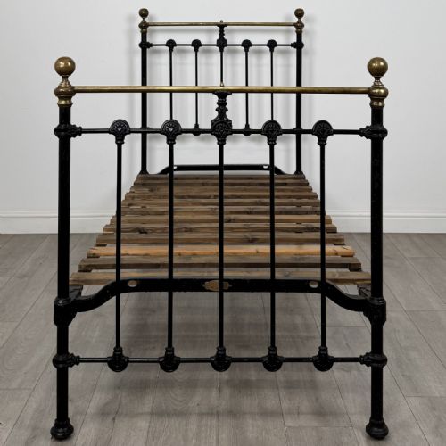 fig 3. A Victorian single bed frame constructed from black cast iron spindles and topped with a brass top rail and ball finials.