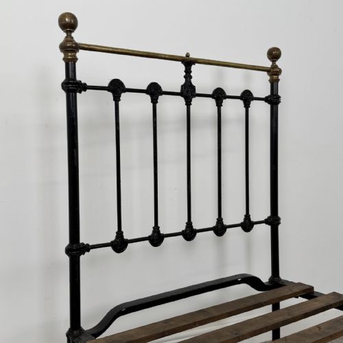 fig 4. A Victorian single bed frame constructed from black cast iron spindles and topped with a brass top rail and ball finials.