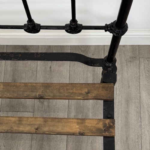 fig 5. A Victorian single bed frame constructed from black cast iron spindles and topped with a brass top rail and ball finials.