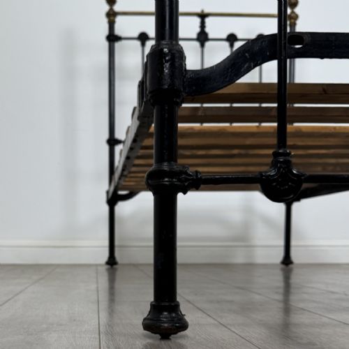 fig 6. A Victorian single bed frame constructed from black cast iron spindles and topped with a brass top rail and ball finials.