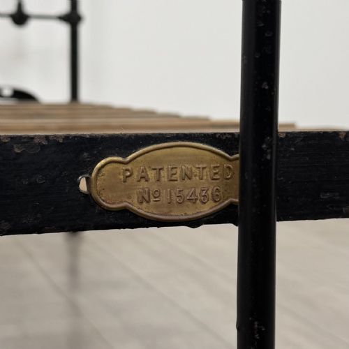 fig 7. A Victorian single bed frame constructed from black cast iron spindles and topped with a brass top rail and ball finials.