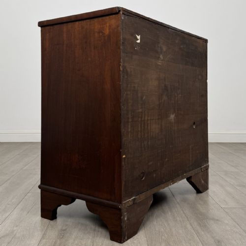 fig 3. A Georgian mahogany bow front chest of drawers featuring three horizontal drawers with brass ring handles and bracket feet.