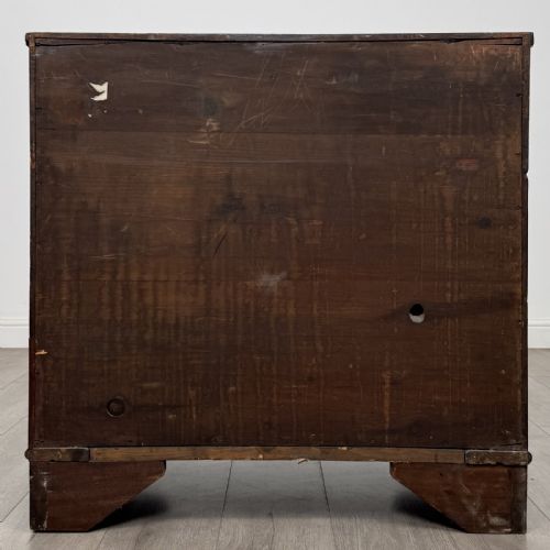 fig 4. A Georgian mahogany bow front chest of drawers featuring three horizontal drawers with brass ring handles and bracket feet.