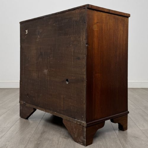 fig 5. A Georgian mahogany bow front chest of drawers featuring three horizontal drawers with brass ring handles and bracket feet.