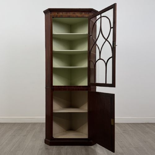 fig 1. An 18th-century Georgian mahogany standing corner cabinet featuring an upper astragal glazed door and a lower solid panel door with oval inlay.