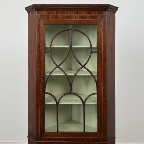 fig 3. An 18th-century Georgian mahogany standing corner cabinet featuring an upper astragal glazed door and a lower solid panel door with oval inlay.